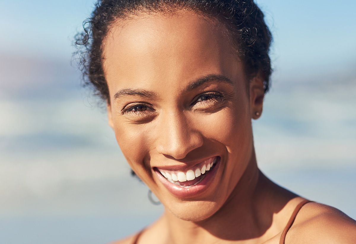 Two smiling young women enjoying the benefits of Elicina snail cream.